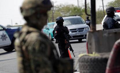 Los agentes de policía estatal y militares mexicanos vigilan en un puesto de control en las de Tamaulipas, México.