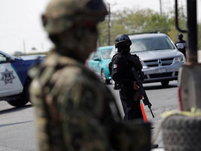 Los agentes de policía estatal y militares mexicanos vigilan en un puesto de control en las de Tamaulipas, México.