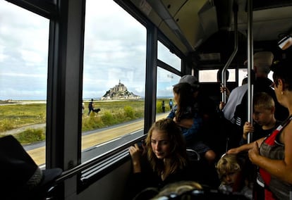 Hay dos maneras de llegar al Mont Saint-Michel (Francia), andando o por carretera. La forma más habitual es coger uno de los autobuses gratuitos que se encuentran a disposición de los turistas en los aparcamientos situados a tres kilómetros del monumento. Por 12 euros puedes despreocuparte del coche durante 24 horas.