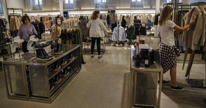 Clientes comparan precios en una tienda de Zara.