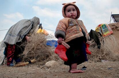 Un niño afgano sujeta sus botas en un campamento de refugiados en las afueras de Mazar-e Sharif, al norte de Kabul (Afganistán). 