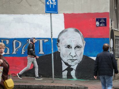 Viandantes caminan junto a una pintada que representa al presidente ruso, Vladímir Putin, en Belgrado, Serbia.