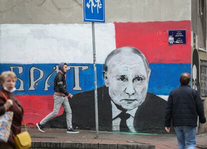 Viandantes caminan junto a una pintada que representa al presidente ruso, Vladímir Putin, en Belgrado, Serbia.