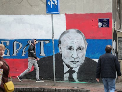 Viandantes caminan junto a una pintada que representa al presidente ruso, Vladímir Putin, en Belgrado, Serbia.