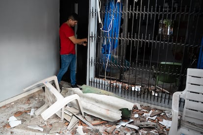 Un residente del barrio La Nueva Base cierra la puerta de su casa mientras ve la afectación que dejó el atentado.