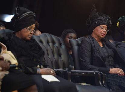 Graca Machel, viuda de Nelson Mandela, (d) y su exesposa Winnie (i), excuchan a los intervinientes en la ceremonia funeral por Nelson Mandela. 