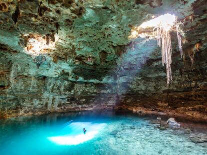 Un hombre nada en un cenote en la península de Yucatán.