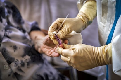 Un sanitario realiza un test de covid-19 a una anciana en una residencia de mayores de la Comunidad Valenciana.