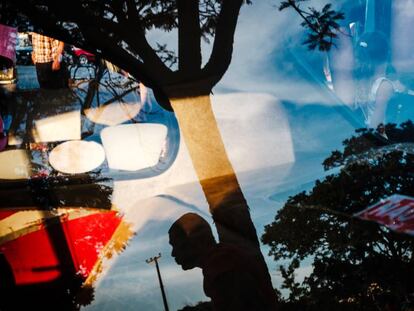 Homem refletido em vidro de carro em encontro do Clube do Opala. Brasília, 2017.