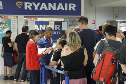 Viajeros ante el `stand´ de Ryanair en el aeropuerto de Barajas.