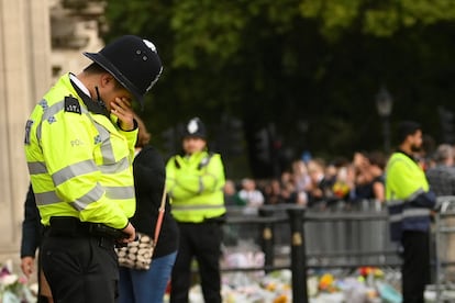 Un oficial de policía muestra su tristeza mientras hace guardia frente al palacio de Buckingham, este viernes. Tras la muerte de su madre, la reina Isabel II de Inglaterra, su heredero, Carlos III, comienza este viernes sus actos oficiales como nuevo jefe del Estado británico. 