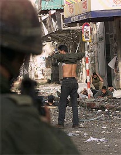 Un soldado israelí apunta a un grupo de palestinos, esta mañana en Ramala.