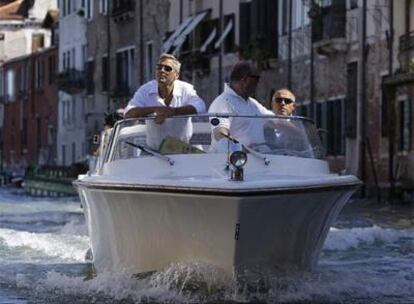 George Clooney (a la izquierda) a su llegada  ayer a su hotel veneciano en taxibote.
