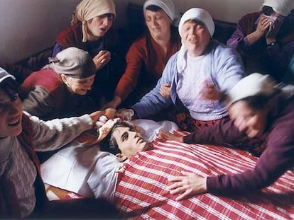 Mujeres albanokosovares lloran en Dragobil ante el cadáver de Ali Murat Pacarizi, soldado del Ejército de Liberación de Kosovo,  en una foto ganadora del Premio Ortega y Gasset de 1999, expuesta en <i>Latidos de un mundo convulso.</i>