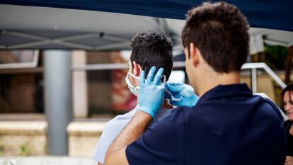 Un paramédico coloca una mascarilla protectora a un visitante recién llegado al hospital Sunninghill de Johanesburgo, Sudáfrica, el 12 de marzo de 2020.