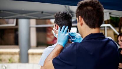 Un paramédico coloca una mascarilla protectora a un visitante recién llegado al hospital Sunninghill de Johanesburgo, Sudáfrica, el 12 de marzo de 2020.