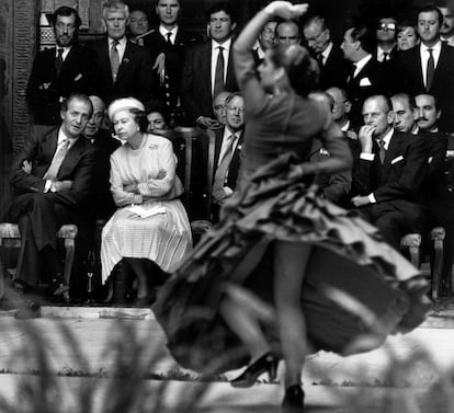 El rey Juan Carlos charla con la reina Isabel II durante una exhibición de flamenco en la visita de los monarcas a Sevilla. A la derecha de la imagen, el príncipe Felipe de Edimburgo.