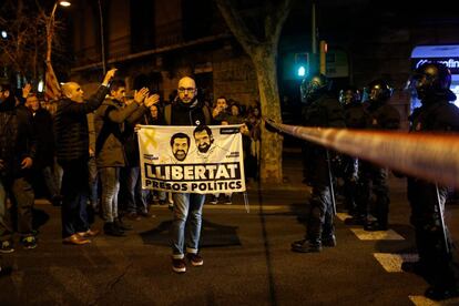 Un manifestant mostra una pancarta demanant la llibertat de presos polítics davant d'un cordó policial a la plaça de Catalunya de Barcelona.