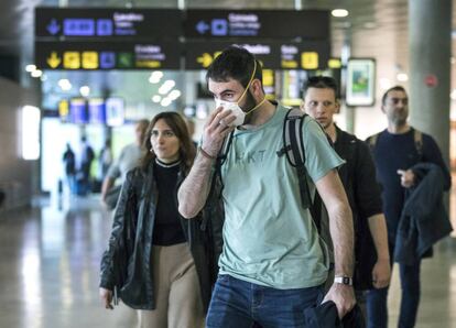 Un turista se protege con mascarilla en el aeropuerto de Valencia. / MÒNICA TORRES (EL PAÍS)