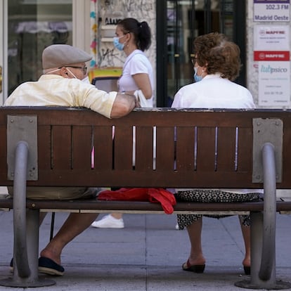 Una pareja de ancianos con mascarilla sentada en un banco de Madrid el pasado julio.