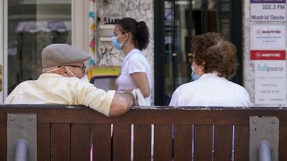 Una pareja de ancianos con mascarilla sentada en un banco de Madrid el pasado julio.