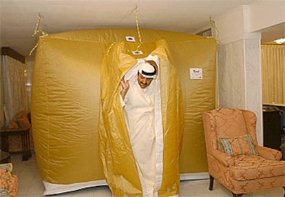 Un kuwaití sale del interior de la tienda de protección química y biológica instalada en el salón de su casa, en septiembre del año pasado.