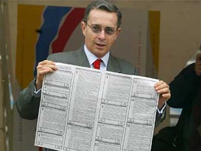 El presidente de Colombia, Álvaro Uribe, muestra su impreso de voto antes de depositarlo.