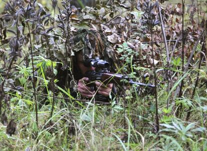Un soldado apunta con su arma escondido entre la maleza durante las maniobras militares conjuntas del ejército ruso y el bielorruso Zapad 2017 en una localización secreta en Bielorrusia.