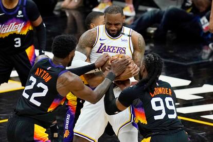 Ayton y Crowder tratan de arrebatarle la pelota a LeBron James.