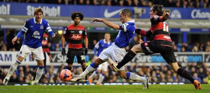 El jugador del Everton Leon Osman remata ante varios jugadores del  Queens Park Rangers.