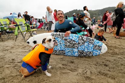 Sin importar cuán grandes o pequeños sean, todos los perros usaban chalecos salvavidas para evitar cualquier percance. En la imagen, Rusty y su dueño, John Garcia, posan junto a su tabla de surf.