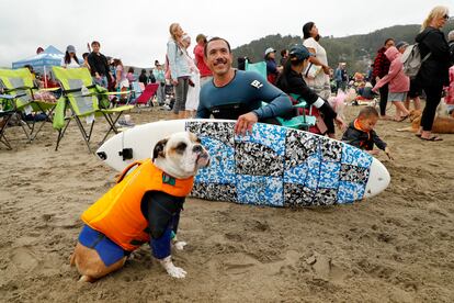 Sin importar cuán grandes o pequeños sean, todos los perros usaban chalecos salvavidas para evitar cualquier percance. En la imagen, Rusty y su dueño, John Garcia, posan junto a su tabla de surf. 