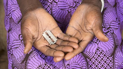 Una mujer sostiene una cuchilla de afeitar, una herramienta utilizada para practicar la mutilación genital femenina.