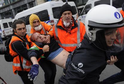 Al menos nueve personas han resultado heridas, dos de ellas policías, en los incidentes ocurridos en Bruselas durante la manifestación contra las políticas de austeridad y recortes en la Unión Europea (UE). En la imagen, un herido es evacuado durante la manifestación, 4 de abril de 2014.