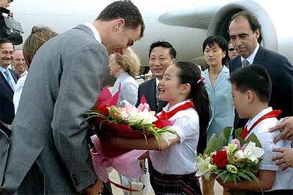 El príncipe Felipe recibe un ramo de magnolias en el aeropuerto de Shanghai.