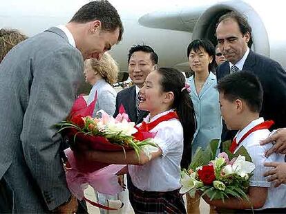 El príncipe Felipe recibe un ramo de magnolias en el aeropuerto de Shanghai.