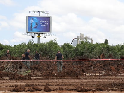 La policía israelí inspecciona el lugar en el que ha caído un misil este domingo, junto a una terminal del aeropuerto Ben Gurion, en Tel Aviv.