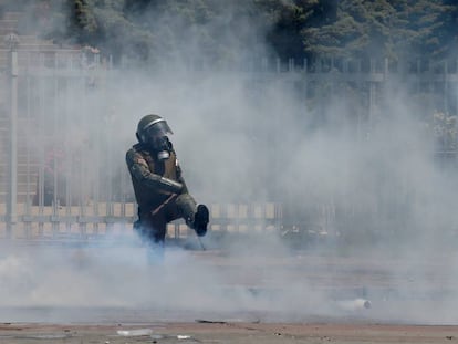 Un miembro de las fuerzas de seguridad chilenas golpea un bote de gas este viernes.