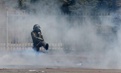 Un miembro de las fuerzas de seguridad chilenas golpea un bote de gas este viernes.