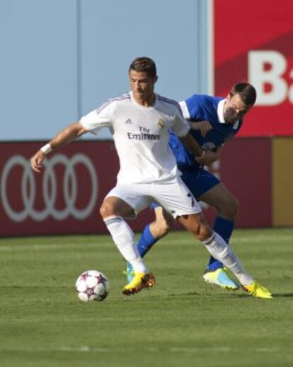 Cristiano Ronaldo disputa un bal&oacute;n con un defensor del Everton. 