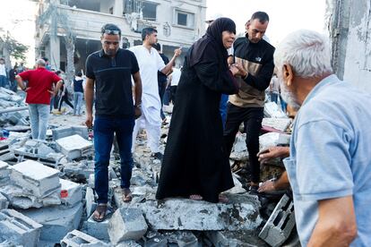 Palestinos caminaban sobre los escombros después de sufrir un ataque israelí en la ciudad de Jan Yunis, al sur de la franja de Gaza. 