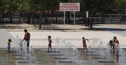 A group of people cool off in the fountains of Juan Carlos I Park in Madrid.