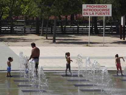 A group of people cool off in the fountains of Juan Carlos I Park in Madrid.