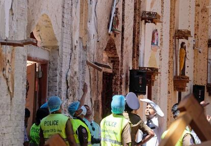 Agentes de la policía investigan en el interior de la iglesia de San Sebastián, en Negombo, este domingo.