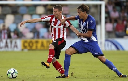 Muniain (i) defiende un balón ante Tomas Pina, del Alavés.