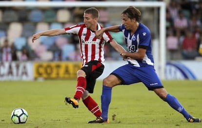 Muniain (i) defiende un bal&oacute;n ante Tomas Pina, del Alav&eacute;s.