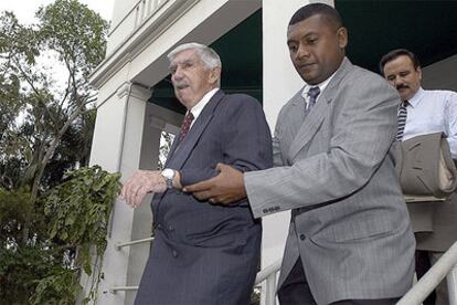 Luis Posada Carriles (izquierda), ayudado a salir del tribunal de Panamá donde compareció el 15 de marzo.