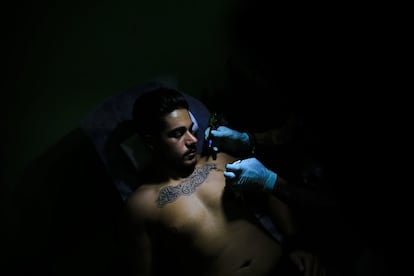 En esta foto, el tatuador Hussein Al-Hussein entinta el pecho del cliente Alodi Issa, de 22 años, con lemas religiosos musulmanes chiítas, en su tienda de tatuajes en el suburbio del sur de Beirut, Líbano. Un número creciente de musulmanes chiítas en el Líbano se están tatuando símbolos religiosos chiítas desde la guerra civil en la vecina Siria, que estalló hace cinco años.