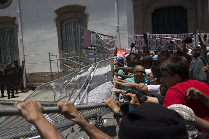 Manifestantes derrubam barreira erguida do lado de fora da Assembleia Legislativa do Rio de Janeiro. 