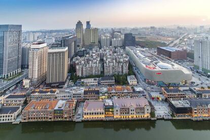 Vista aérea de Wuhan, en la que se observa la convivencia de las casas bajas tradicionales, con los bloques de viviendas de corte soviético, rascacielos corporativos del estilo de los de los ochenta y, a la derecha, el centro comercial Hanjie Wanda, del estudio holandés UN Estudio. |